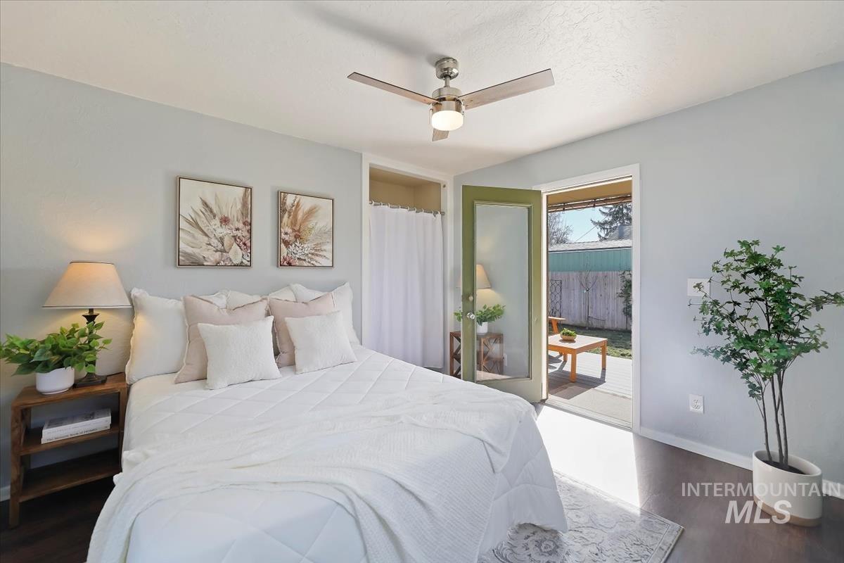 Bedroom with dark wood-type flooring, access to exterior, and a ceiling fan
