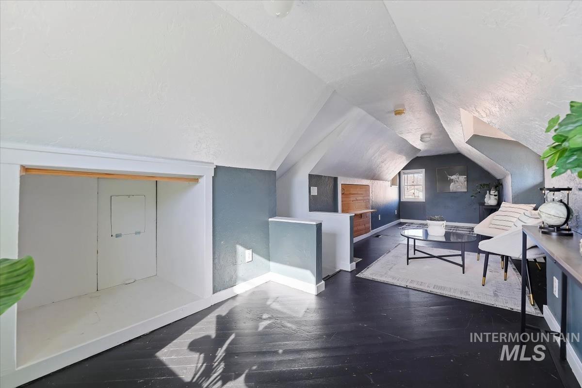 Interior space featuring dark wood-style flooring and lofted ceiling
