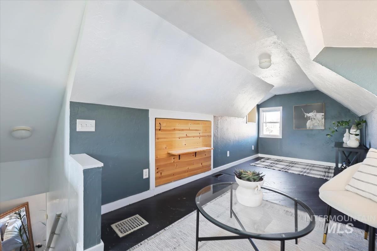 Living area with baseboards and wood finished floors
