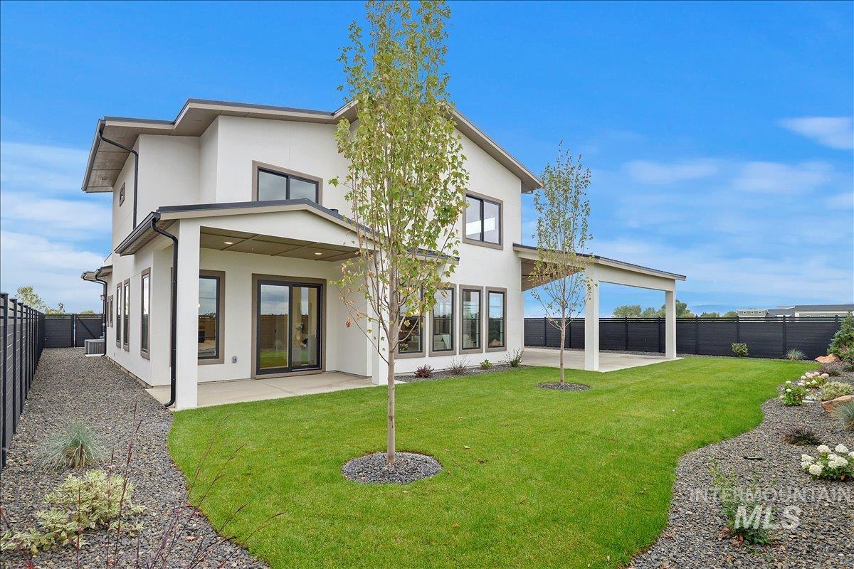 Rear view of property featuring a patio area, a fenced backyard, and stucco siding