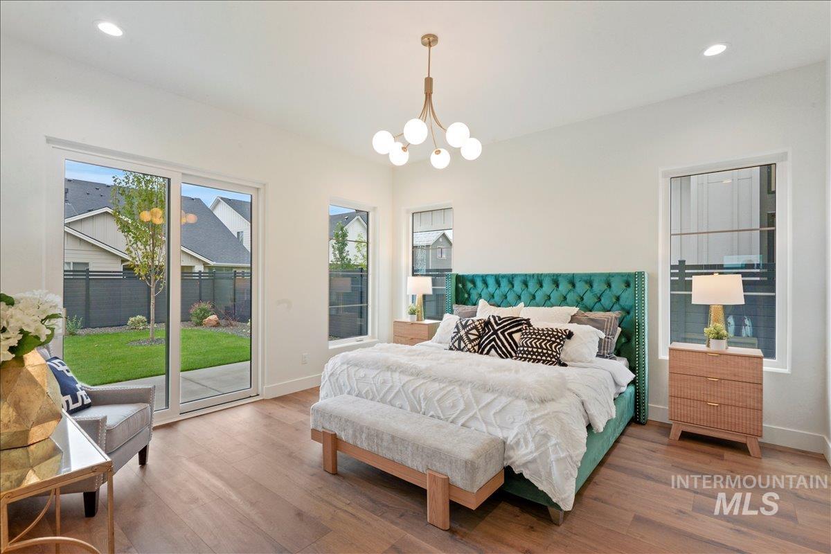 Bedroom featuring recessed lighting, access to exterior, wood finished floors, and a chandelier