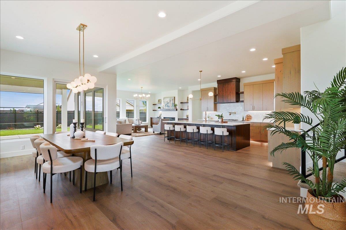Dining area featuring a chandelier, dark wood finished floors, recessed lighting, and beamed ceiling