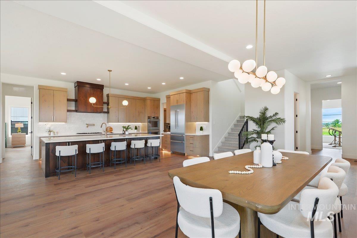Dining room with dark wood-style floors, stairs, and recessed lighting