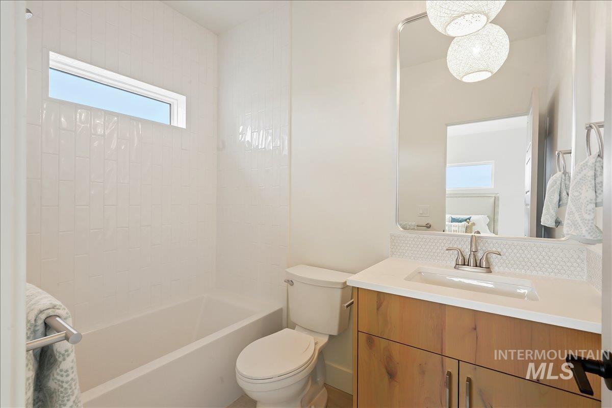 Bathroom with healthy amount of natural light, vanity, and shower / bathtub combination