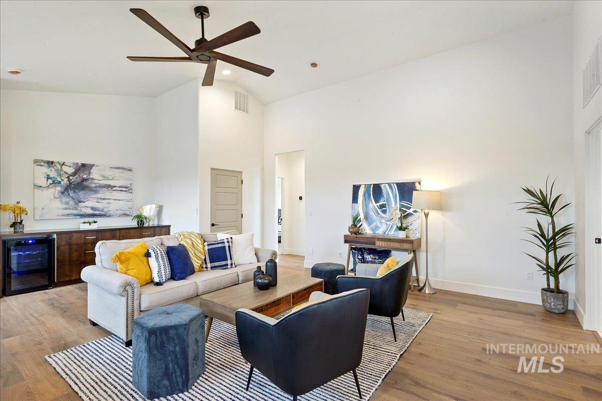 Living room featuring high vaulted ceiling, wine cooler, wood finished floors, a ceiling fan, and recessed lighting