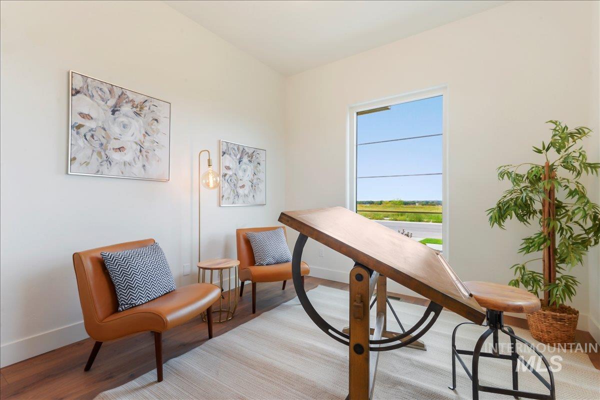 Living area featuring wood finished floors and a desk