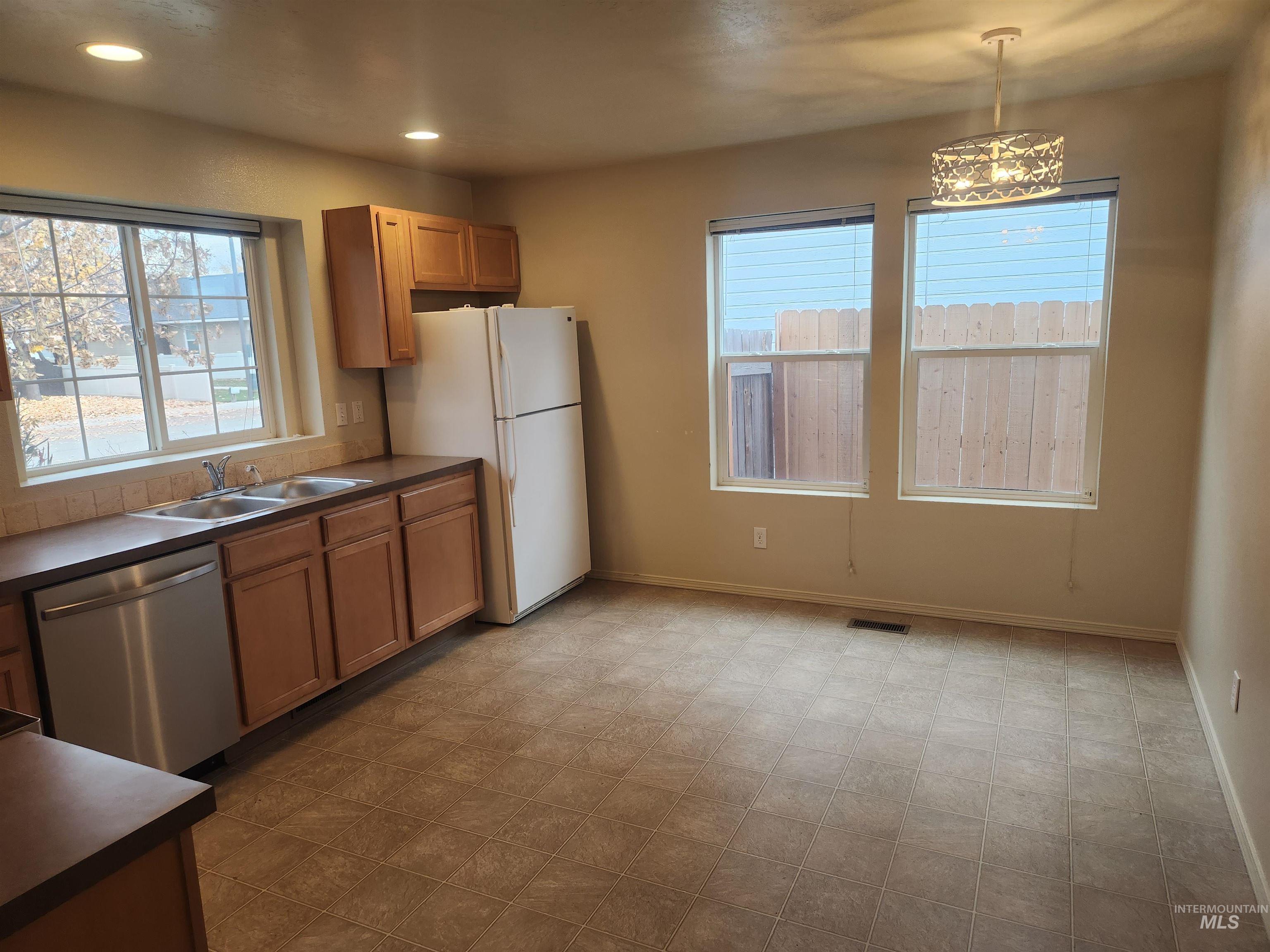 Kitchen with white appliances, recessed lighting, dark countertops, and light carpet