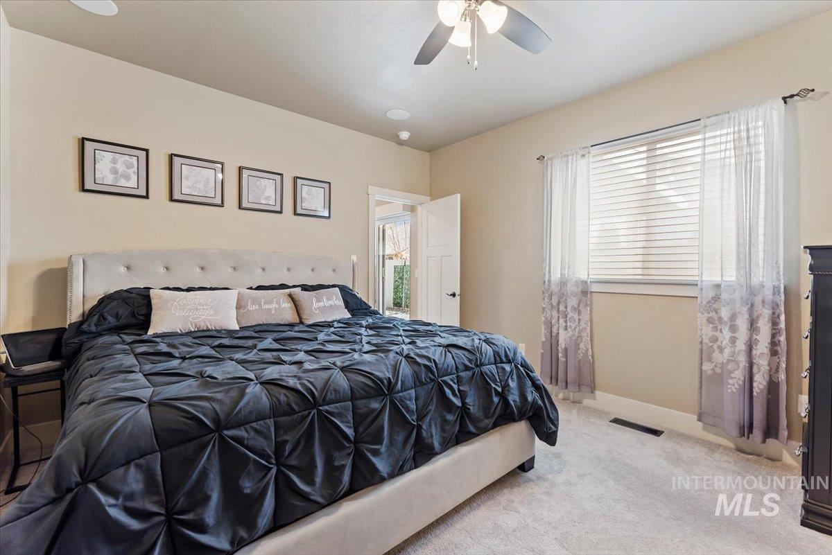 Carpeted bedroom featuring a ceiling fan and baseboards