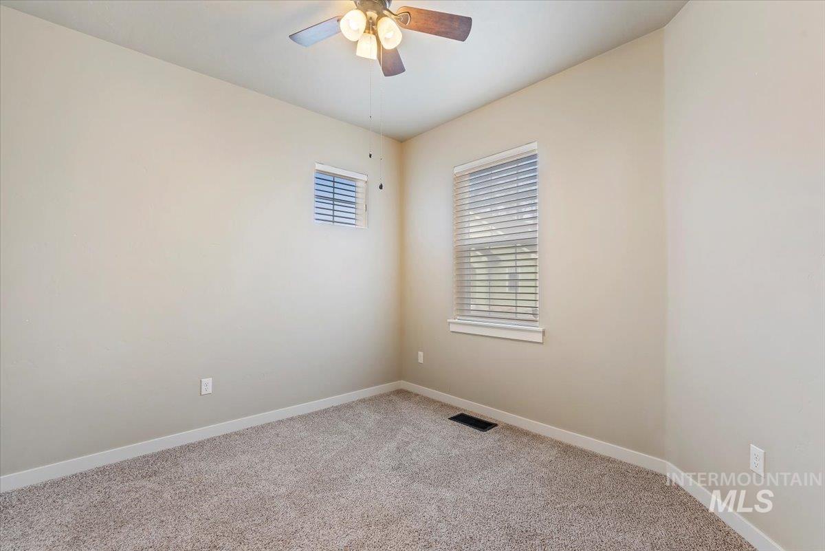 Spare room featuring light colored carpet and ceiling fan