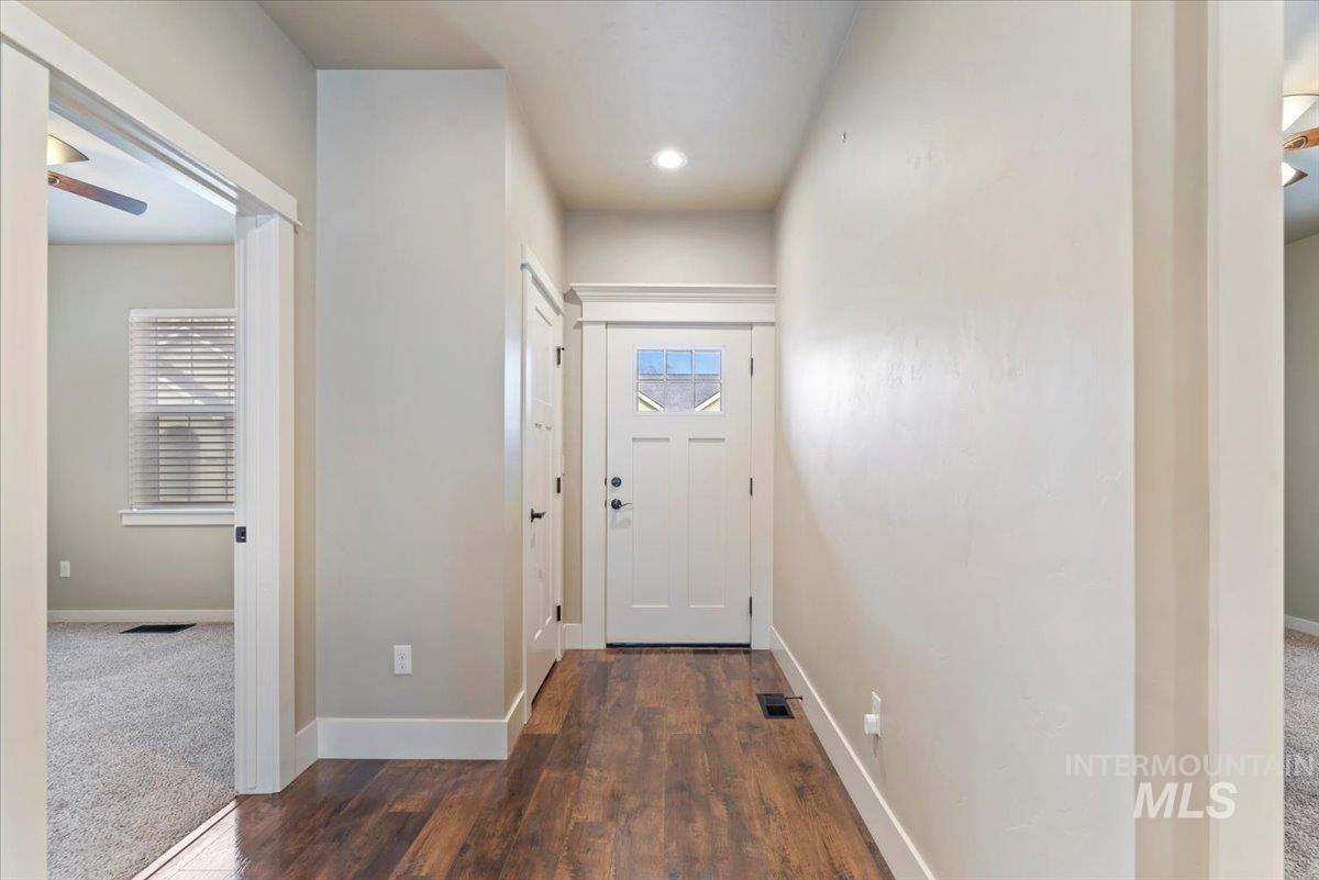 Doorway to outside featuring wood finished floors, plenty of natural light, and carpet floors