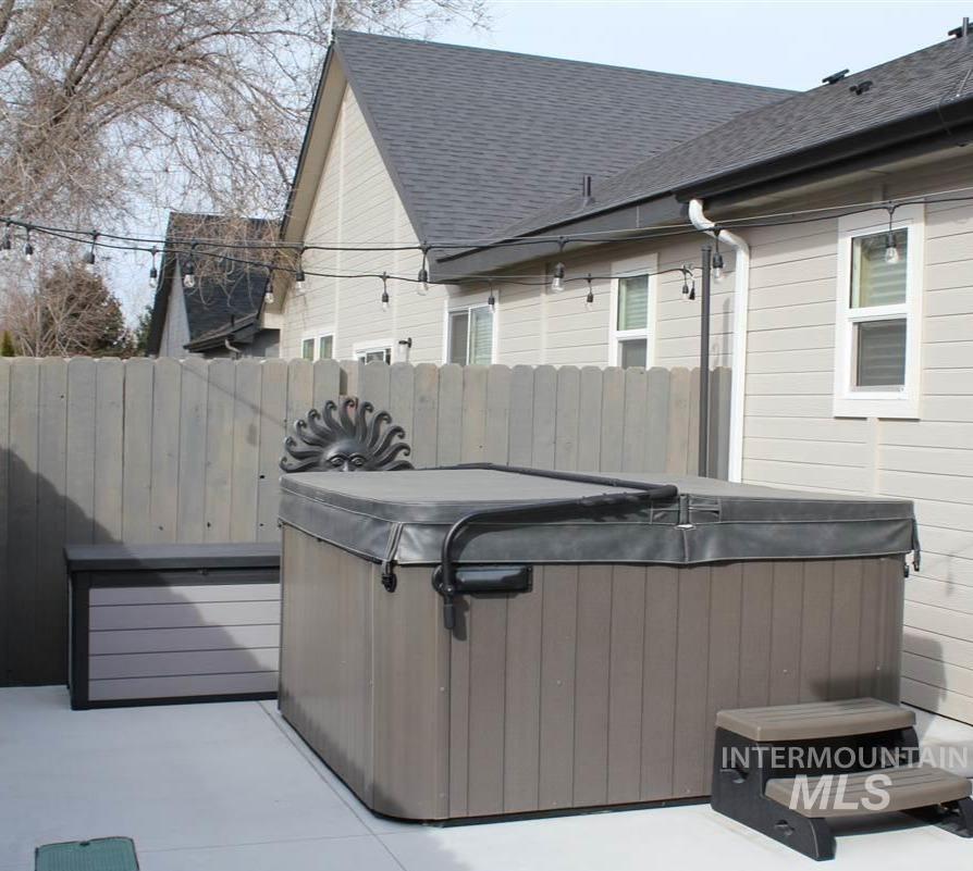Wooden terrace with a hot tub and a patio area