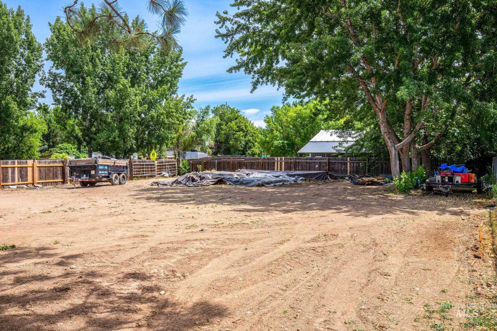 Fenced backyard with view of wooded area