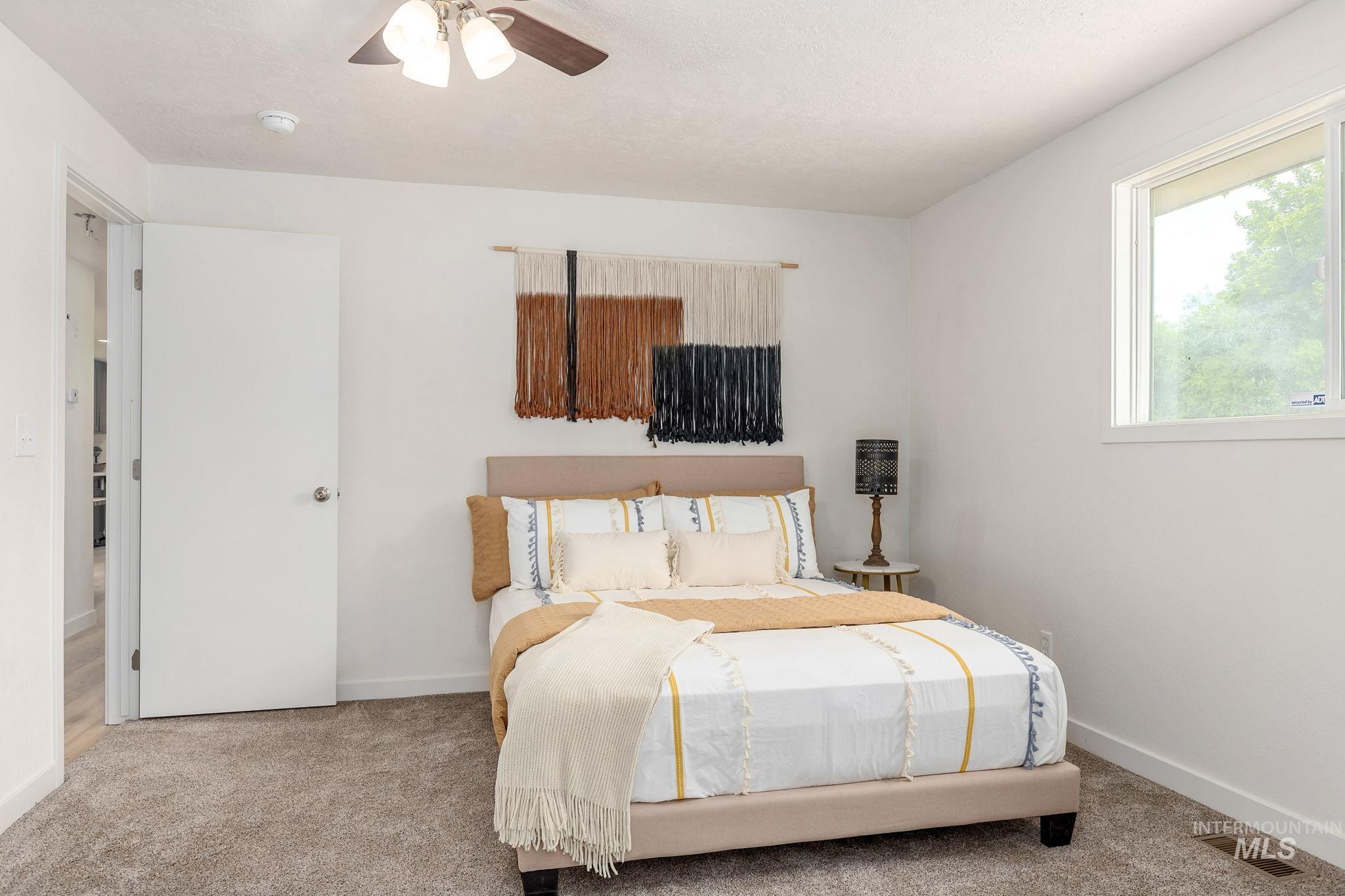 Carpeted bedroom with baseboards and ceiling fan