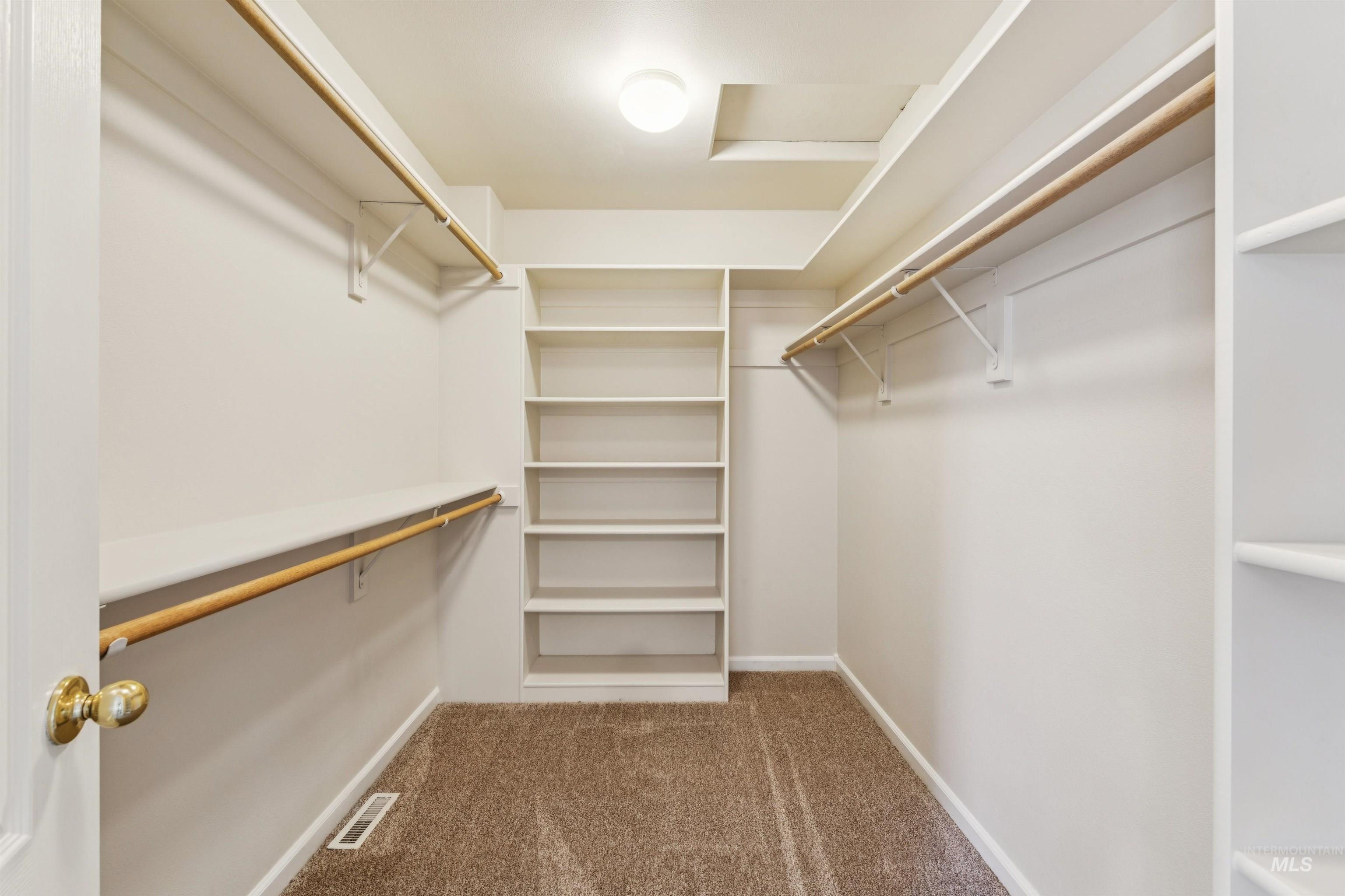 Spacious closet featuring light colored carpet and attic access