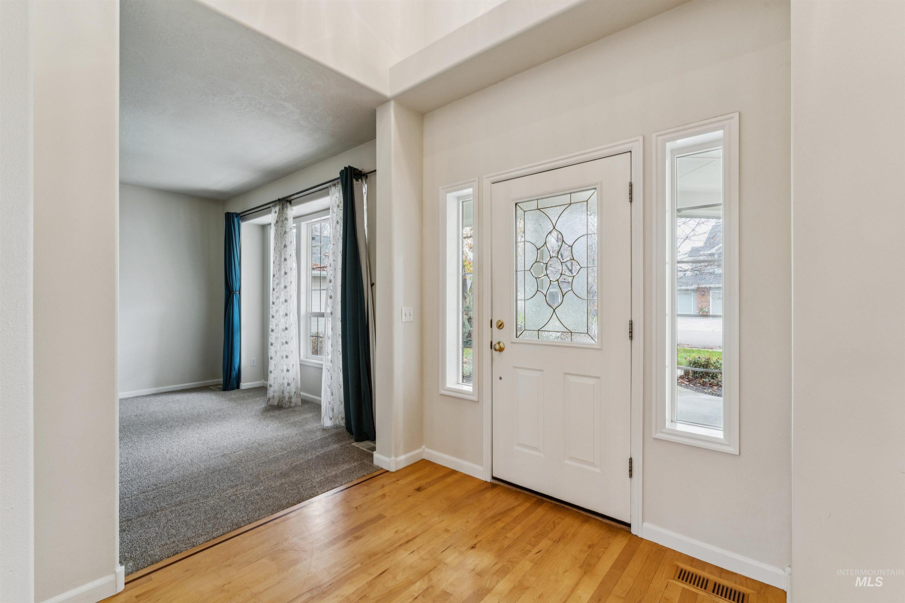 Foyer with healthy amount of natural light and light wood-style flooring