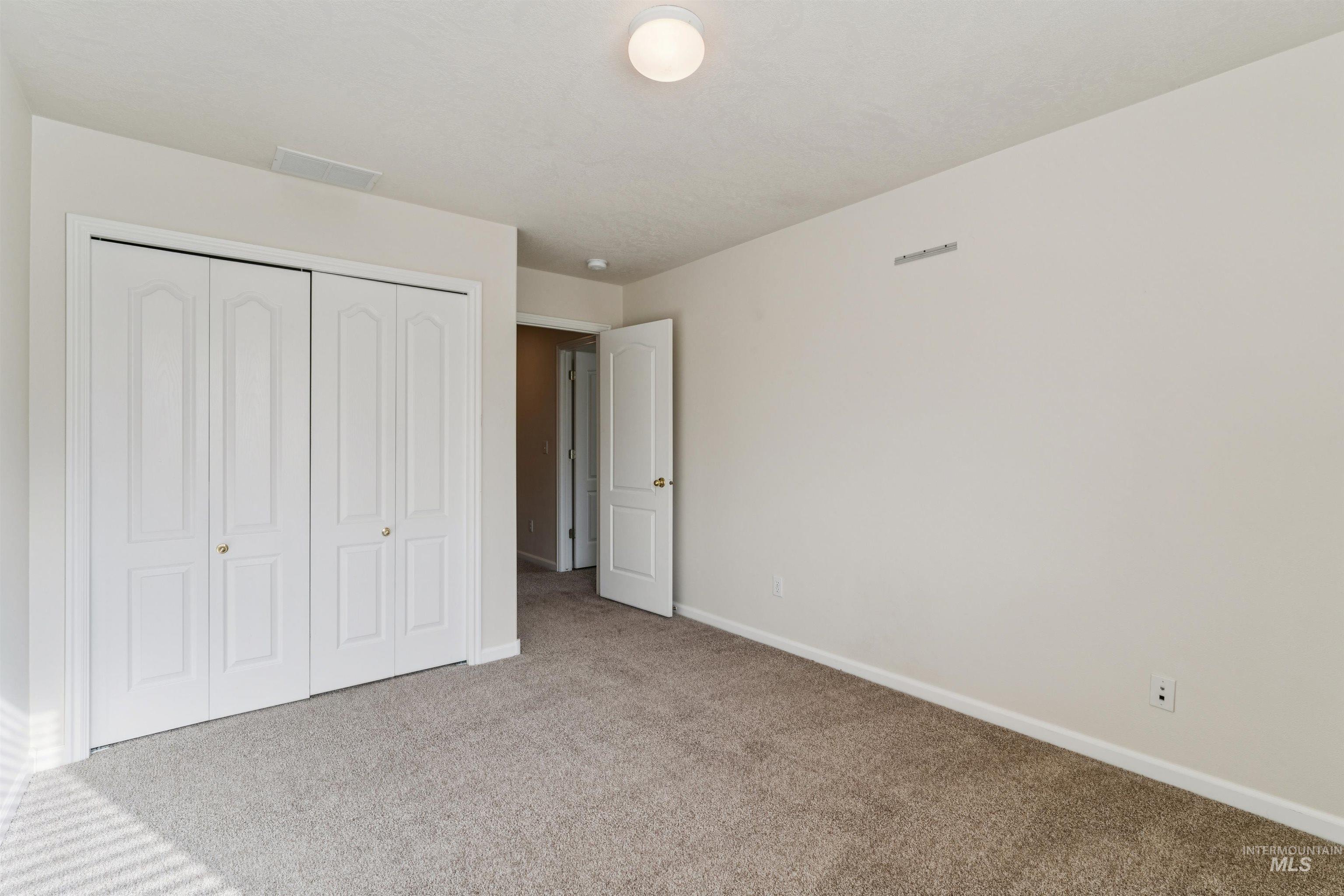 Unfurnished bedroom featuring carpet flooring and a closet