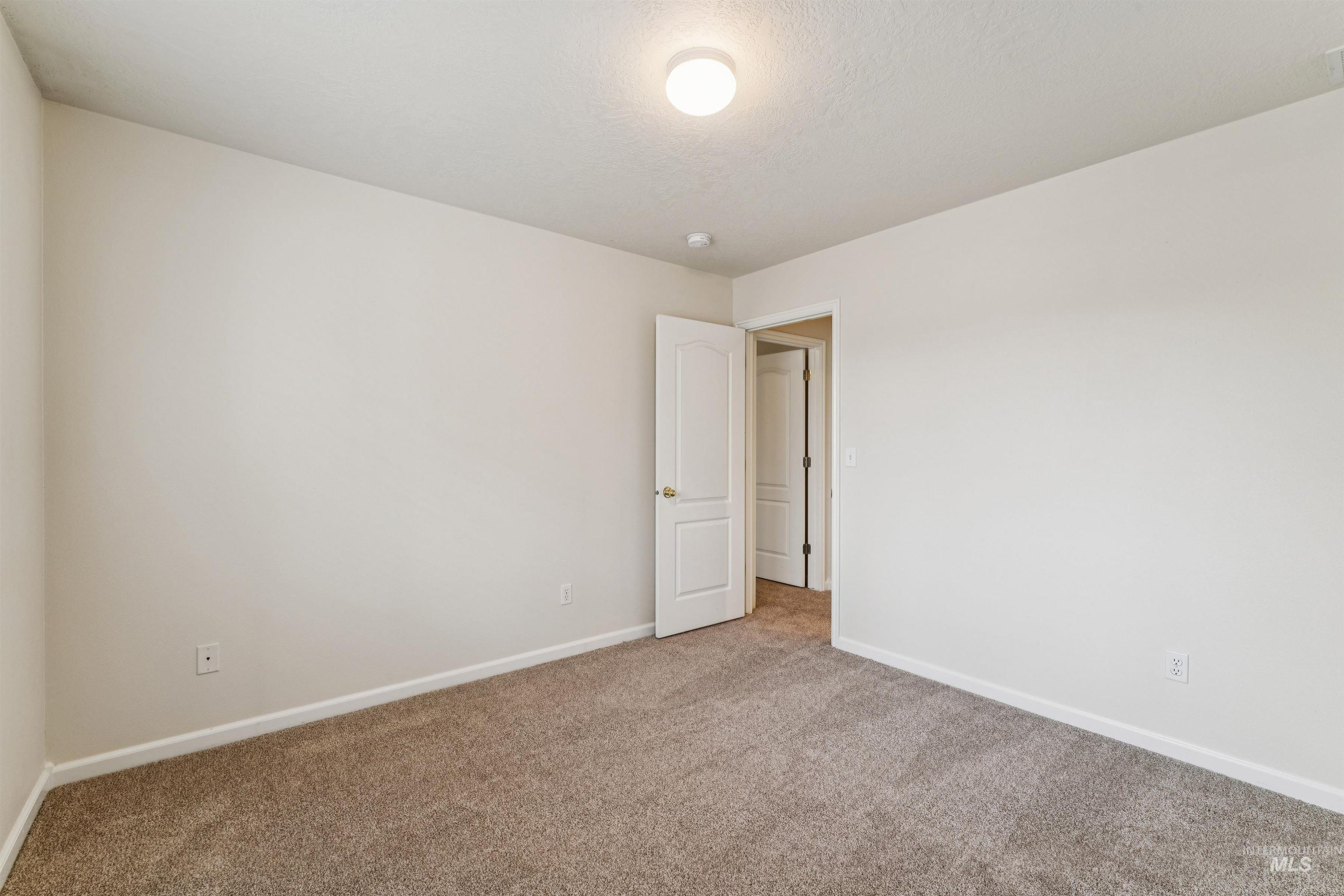 Carpeted empty room featuring baseboards