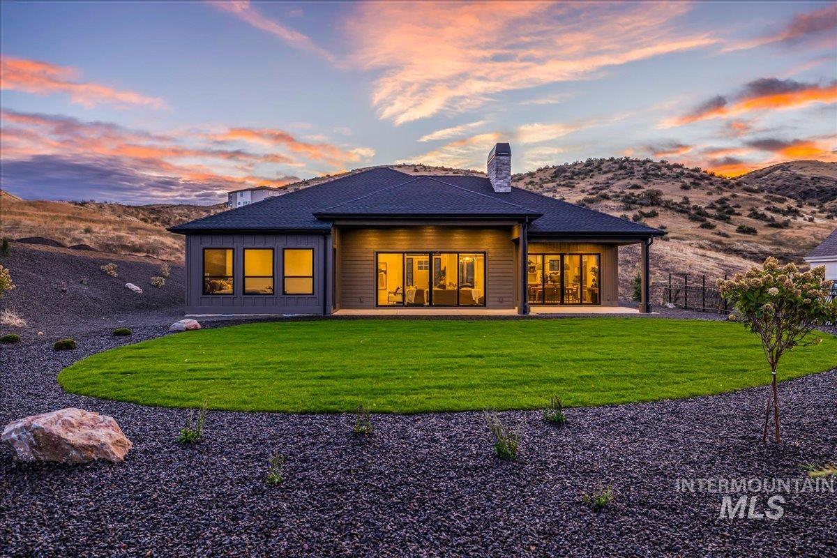 Back of property featuring a patio area, a chimney, and a mountain view