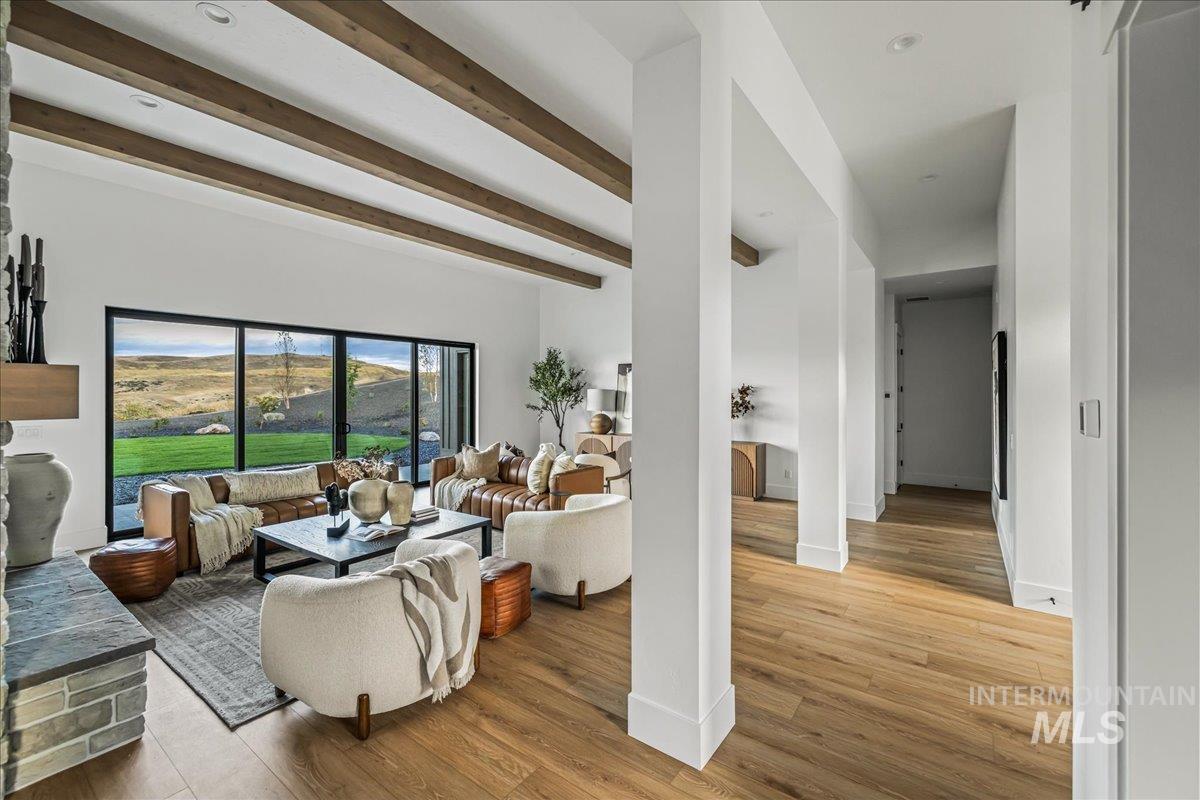 Living area with beamed ceiling and wood finished floors