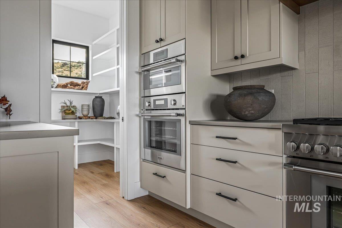 Kitchen with stainless steel appliances, light wood-type flooring, and light countertops