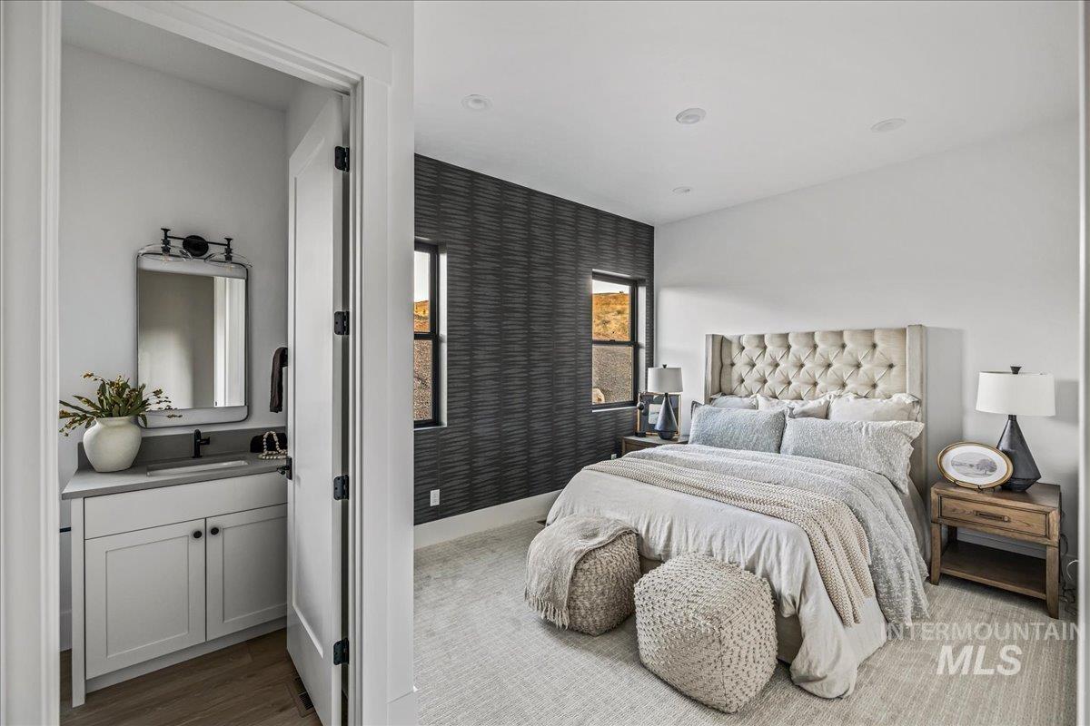 Bedroom featuring wood finished floors and ensuite bath