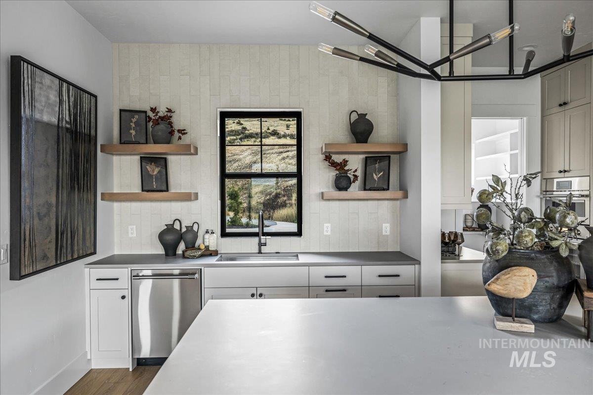 Kitchen with stainless steel appliances, open shelves, decorative backsplash, and white cabinetry