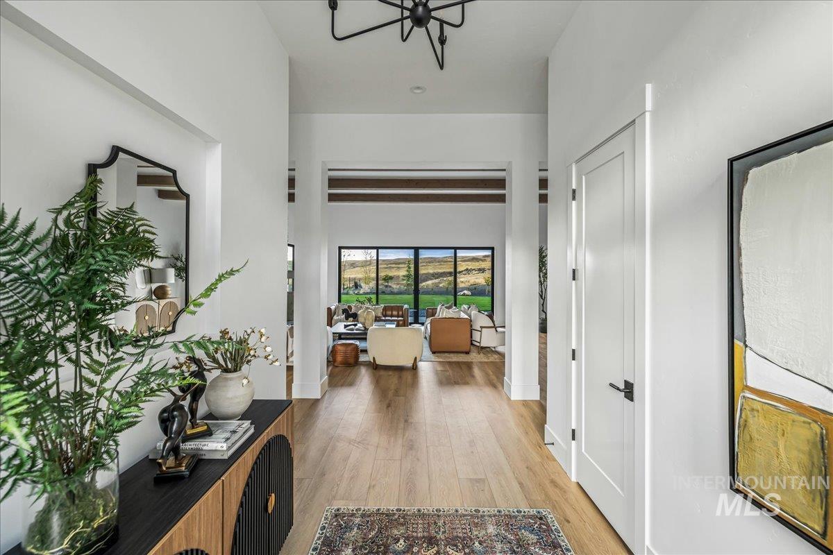 Hall featuring light wood-type flooring and a chandelier