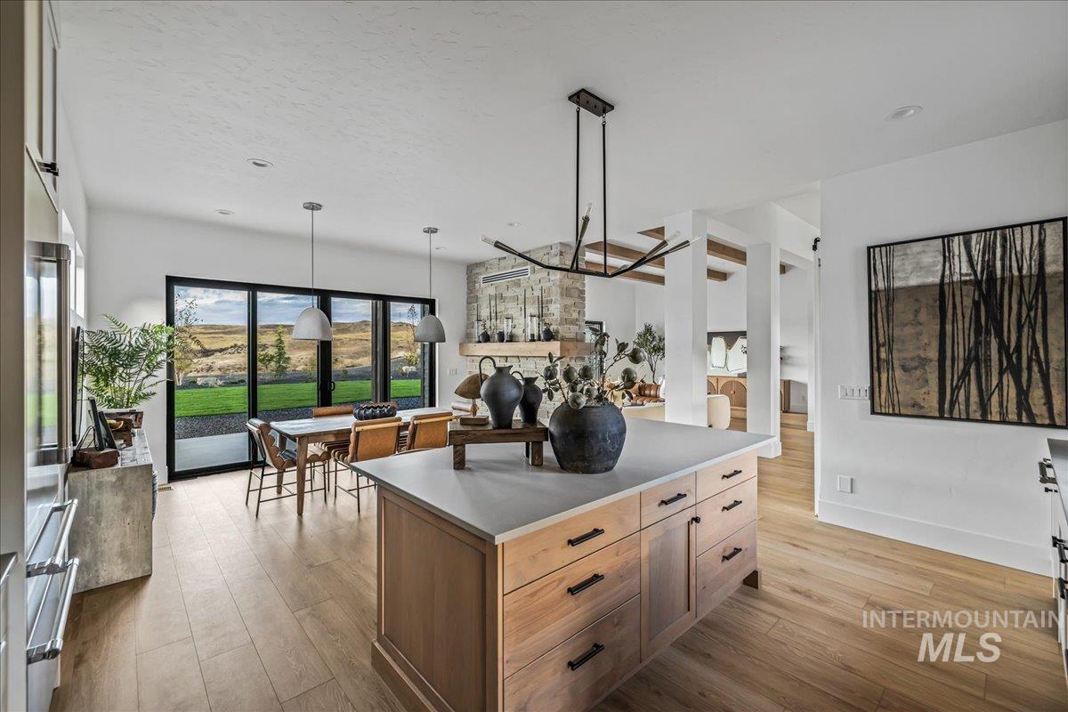 Kitchen featuring light wood-type flooring, hanging light fixtures, a center island, and a textured ceiling