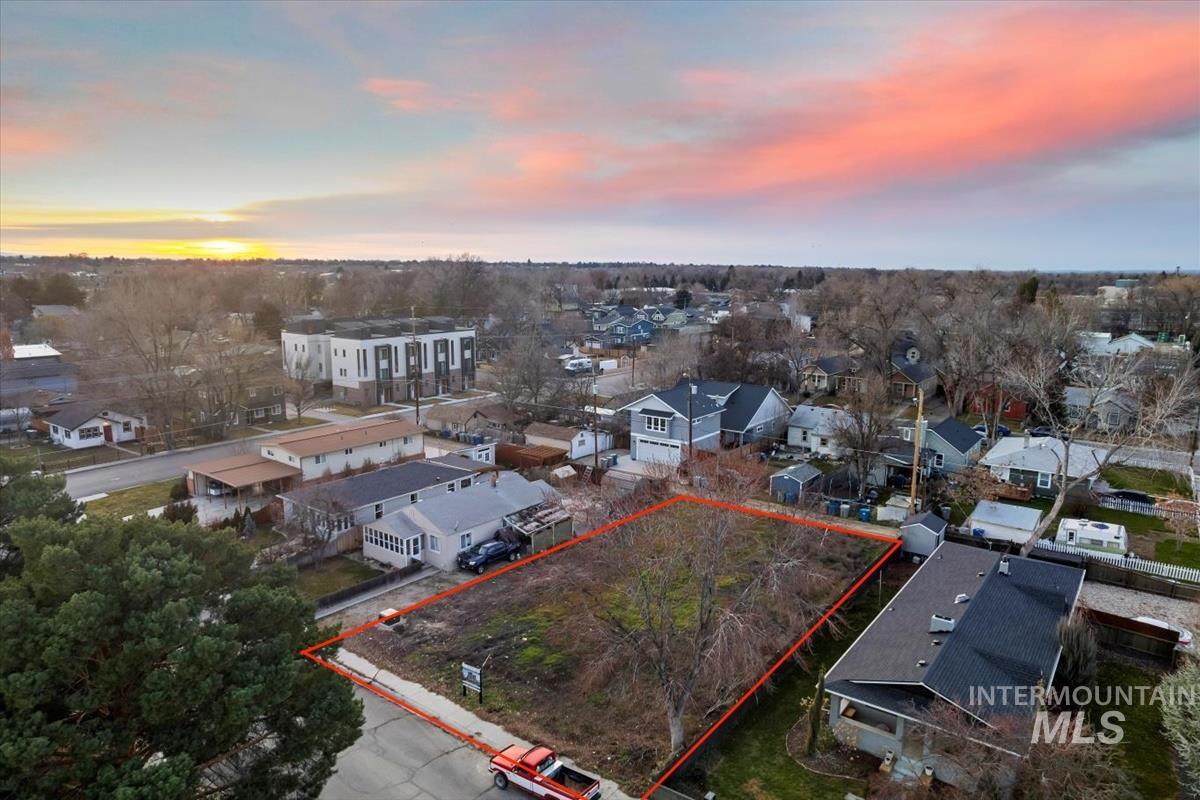 Aerial view at dusk of property parcel outlined and a residential view