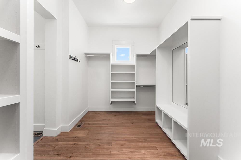 Walk in closet with wood finished floors