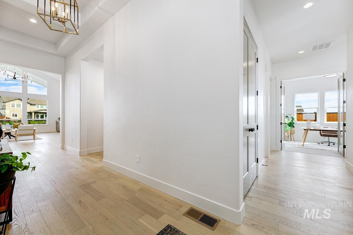Hall featuring plenty of natural light, recessed lighting, light wood finished floors, a chandelier, and a desk