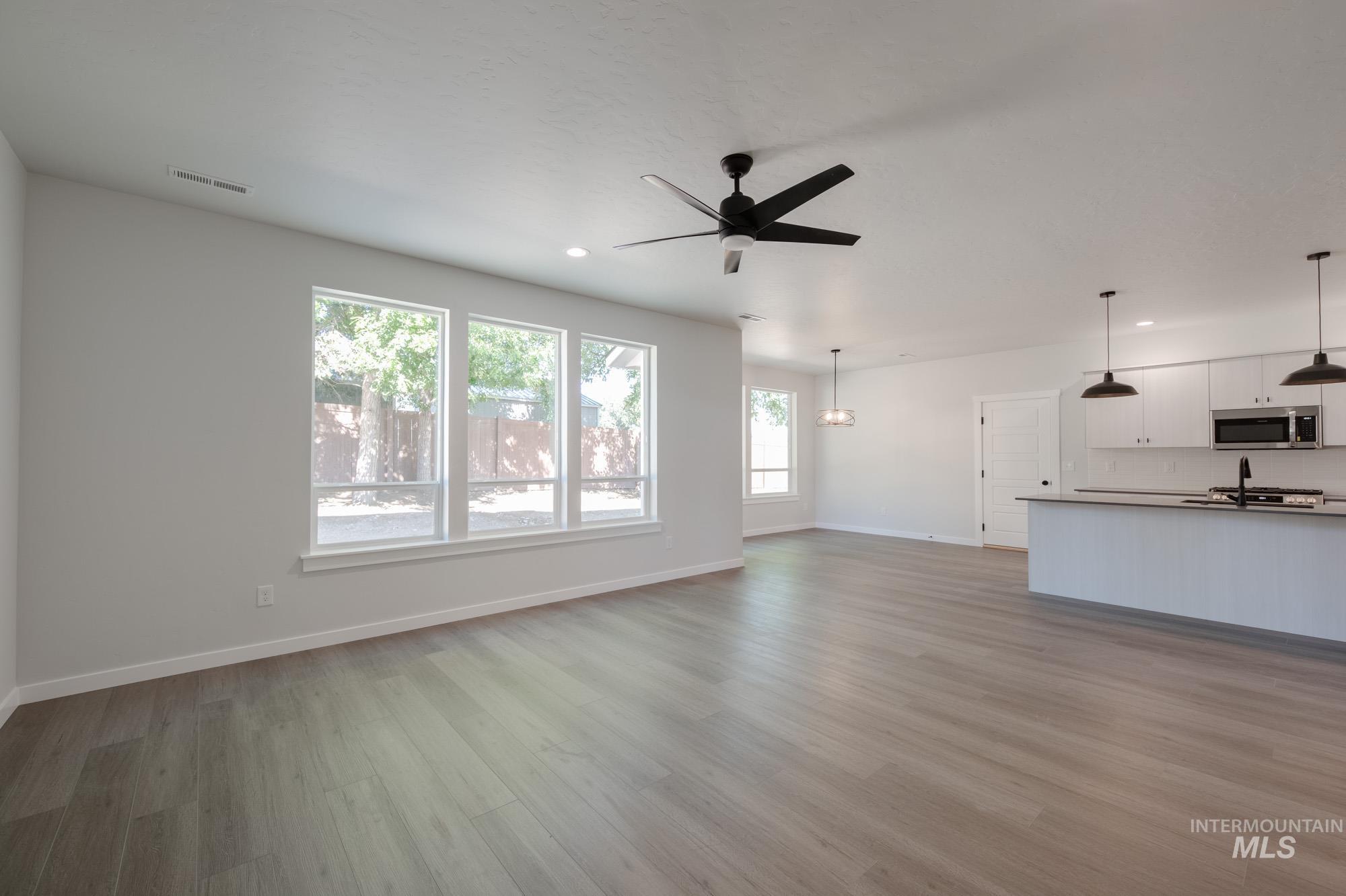 Unfurnished living room featuring light wood-style flooring, recessed lighting, and ceiling fan