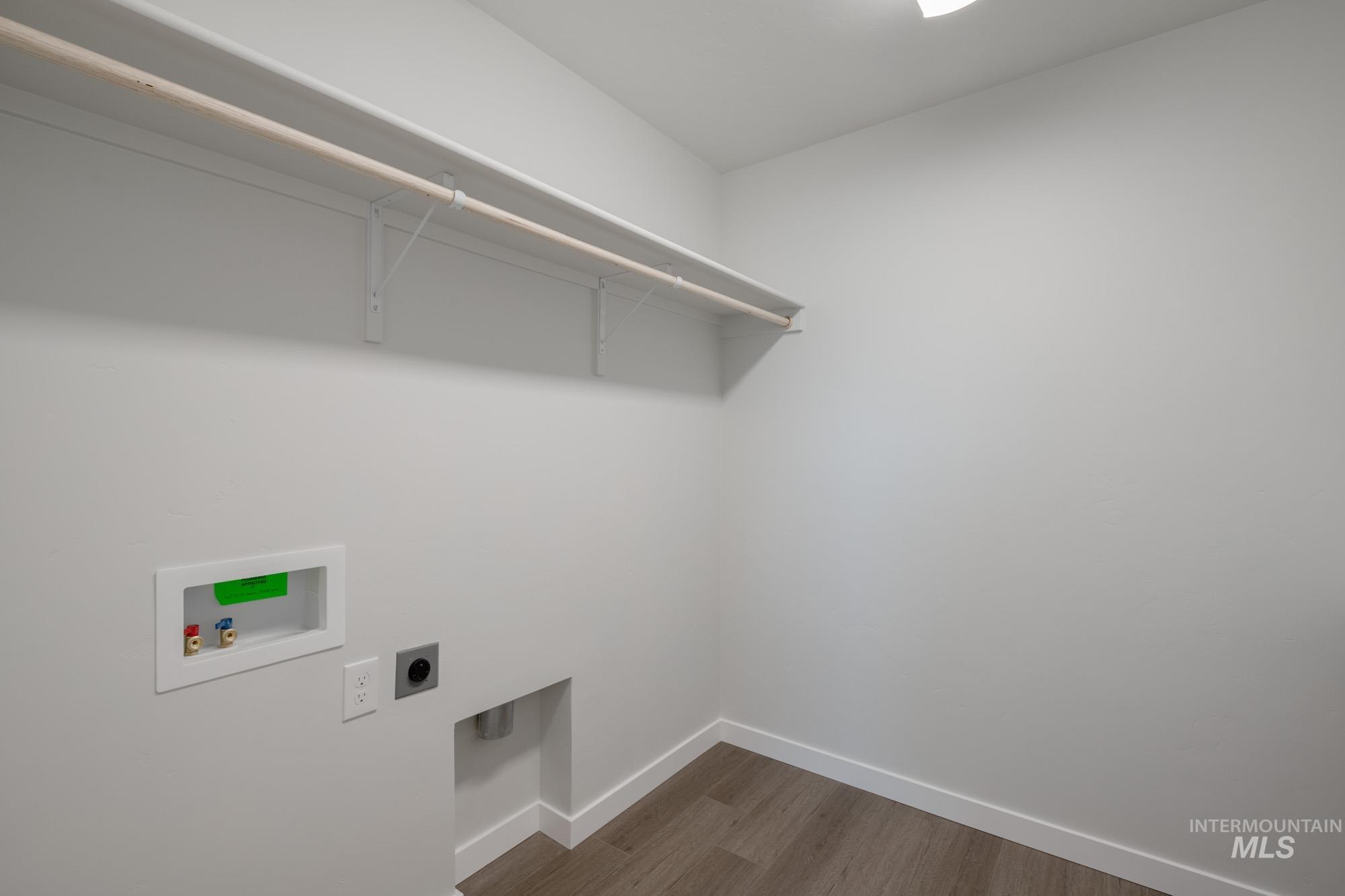 Laundry room featuring hookup for a washing machine, hookup for an electric dryer, and dark wood finished floors