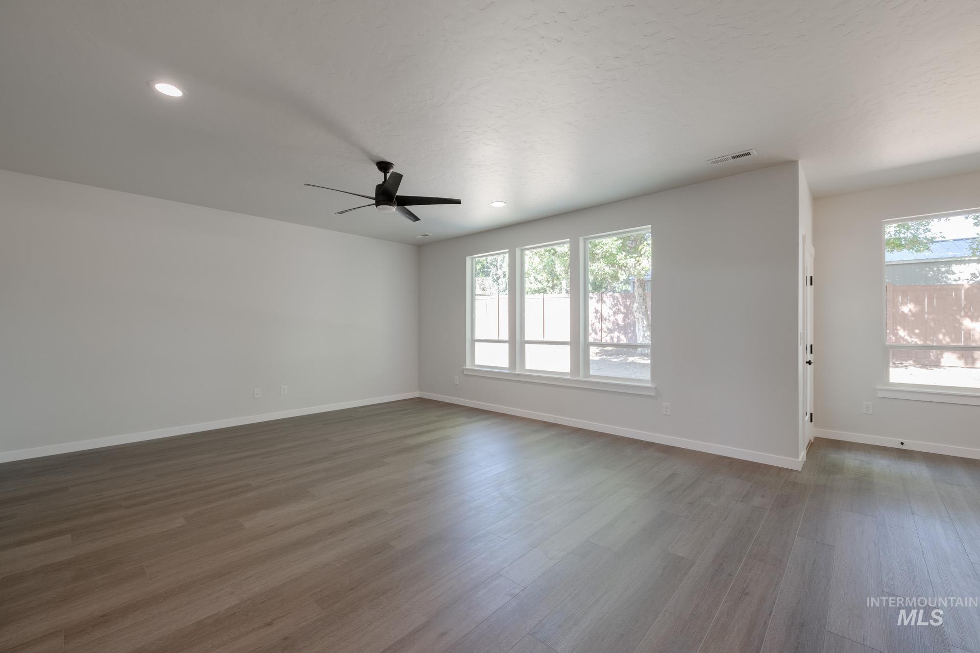 Spare room featuring ceiling fan, dark wood-style flooring, and recessed lighting