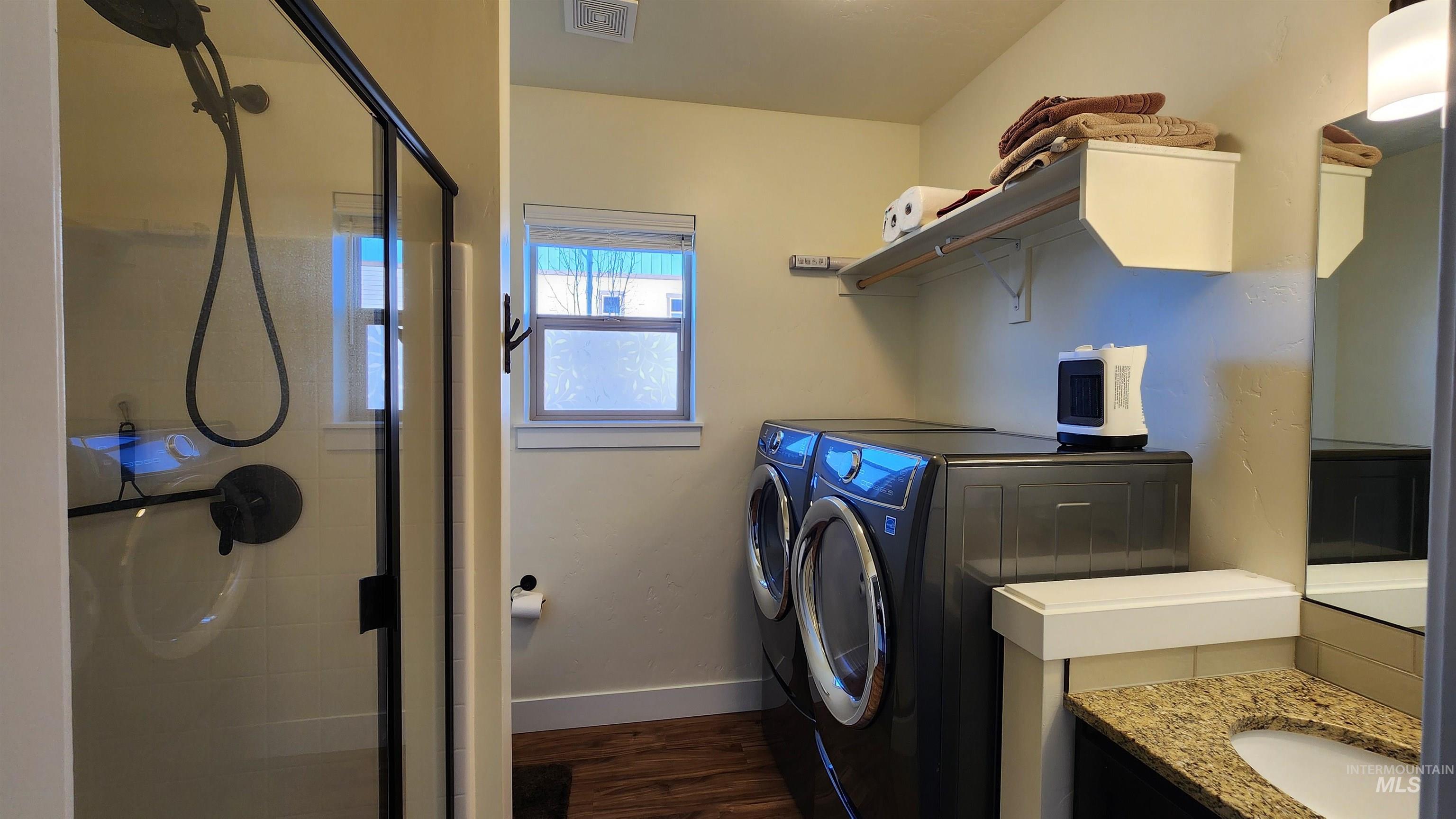 Laundry room and bathroom combo.  Granite countertops, shower and side-by-side washer/dryer.