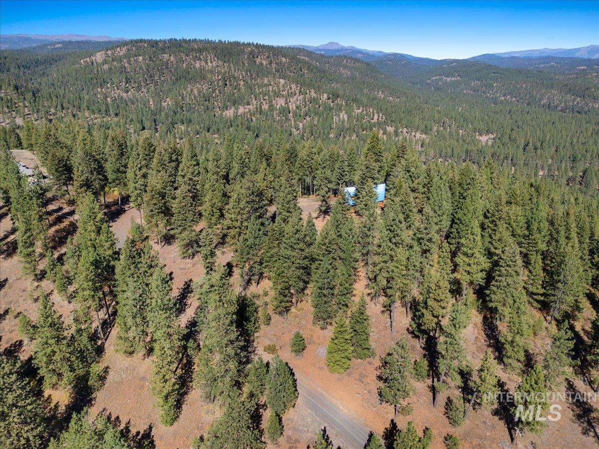 Aerial view of property and surrounding area featuring mountains
