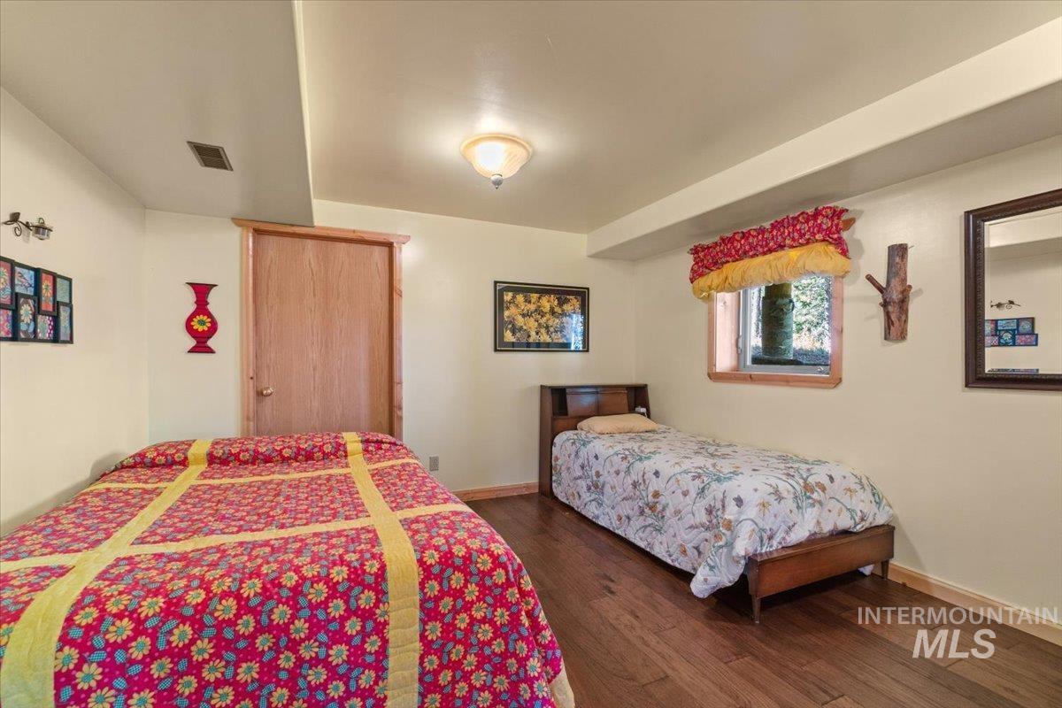 Bedroom with dark wood-style floors and baseboards