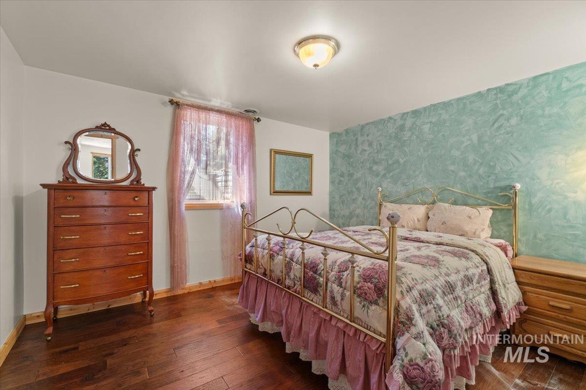 Bedroom with dark wood-type flooring and wallpapered walls