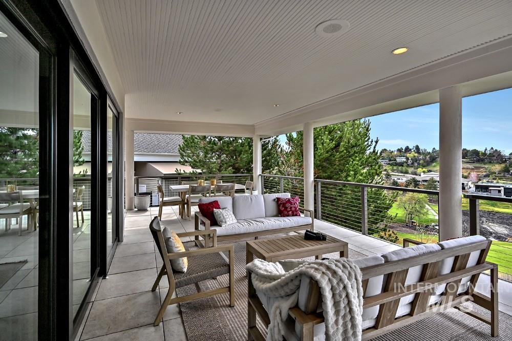 Expansive covered patio featuring a slatted ceiling, recessed lighting, and large format tile flooring