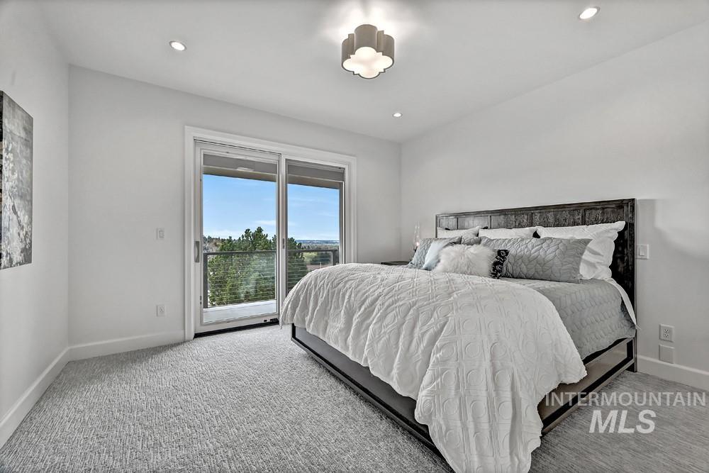 Bedroom featuring a sliding glass door to an outdoor space, recessed lighting, and a decorative flush mount light fixture