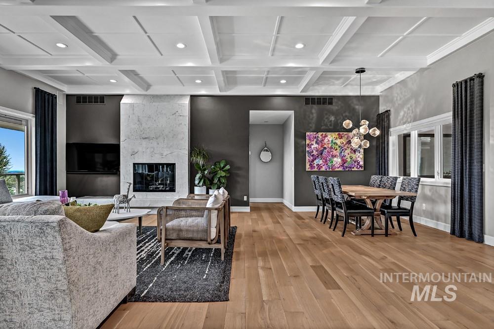 Open-concept living area with coffered ceilings and wood-finish flooring