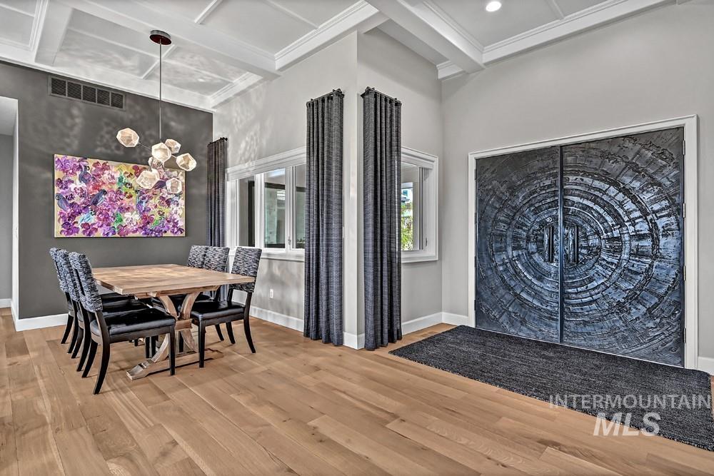 Entryway featuring ornate double doors, wood-finish flooring, and a coffered ceiling