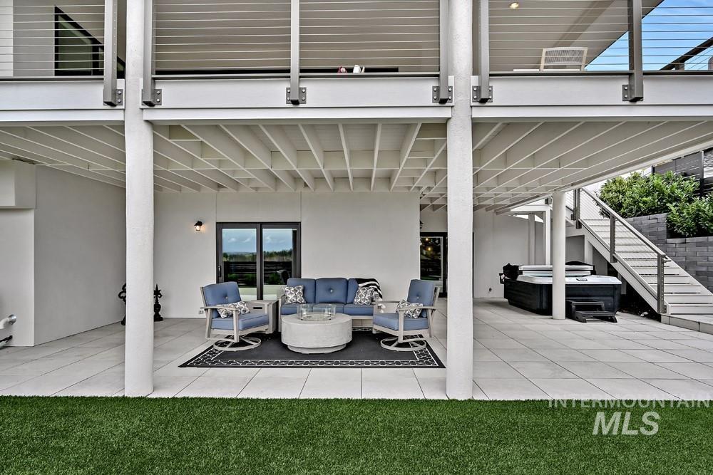 Expansive covered patio featuring a tiled surface, overhead structural beams, and direct access to the interior via sliding glass doors