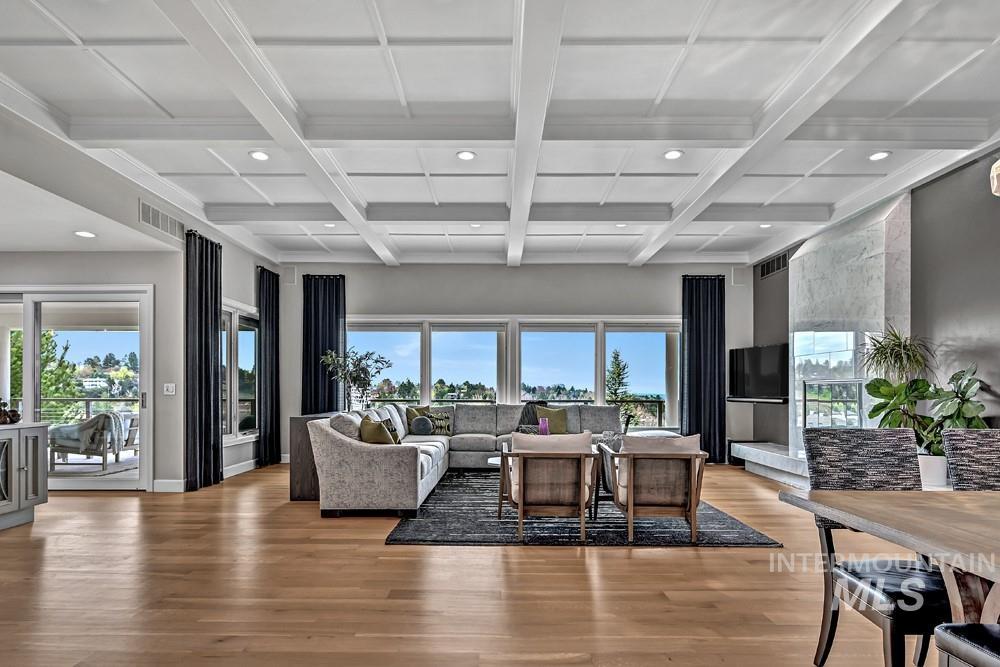 Spacious open-concept interior featuring light wood-finish flooring and a coffered ceiling with recessed lighting