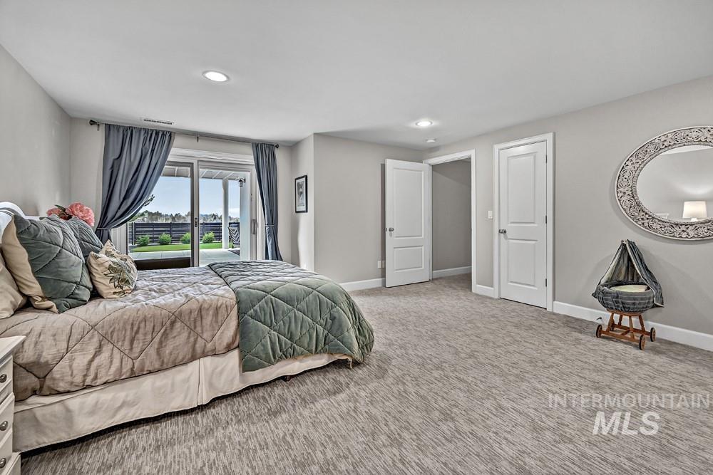 Spacious room featuring light gray walls, recessed lighting, and patterned carpeting