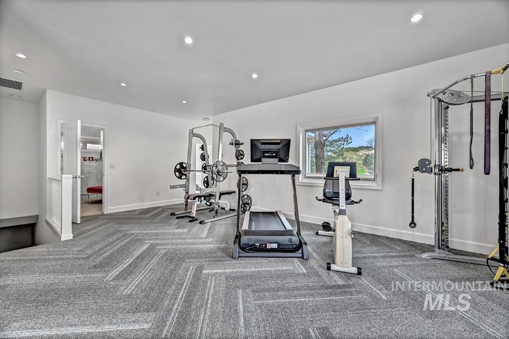 Spacious room featuring patterned carpet flooring, recessed lighting, and a single window offering exterior scenery
