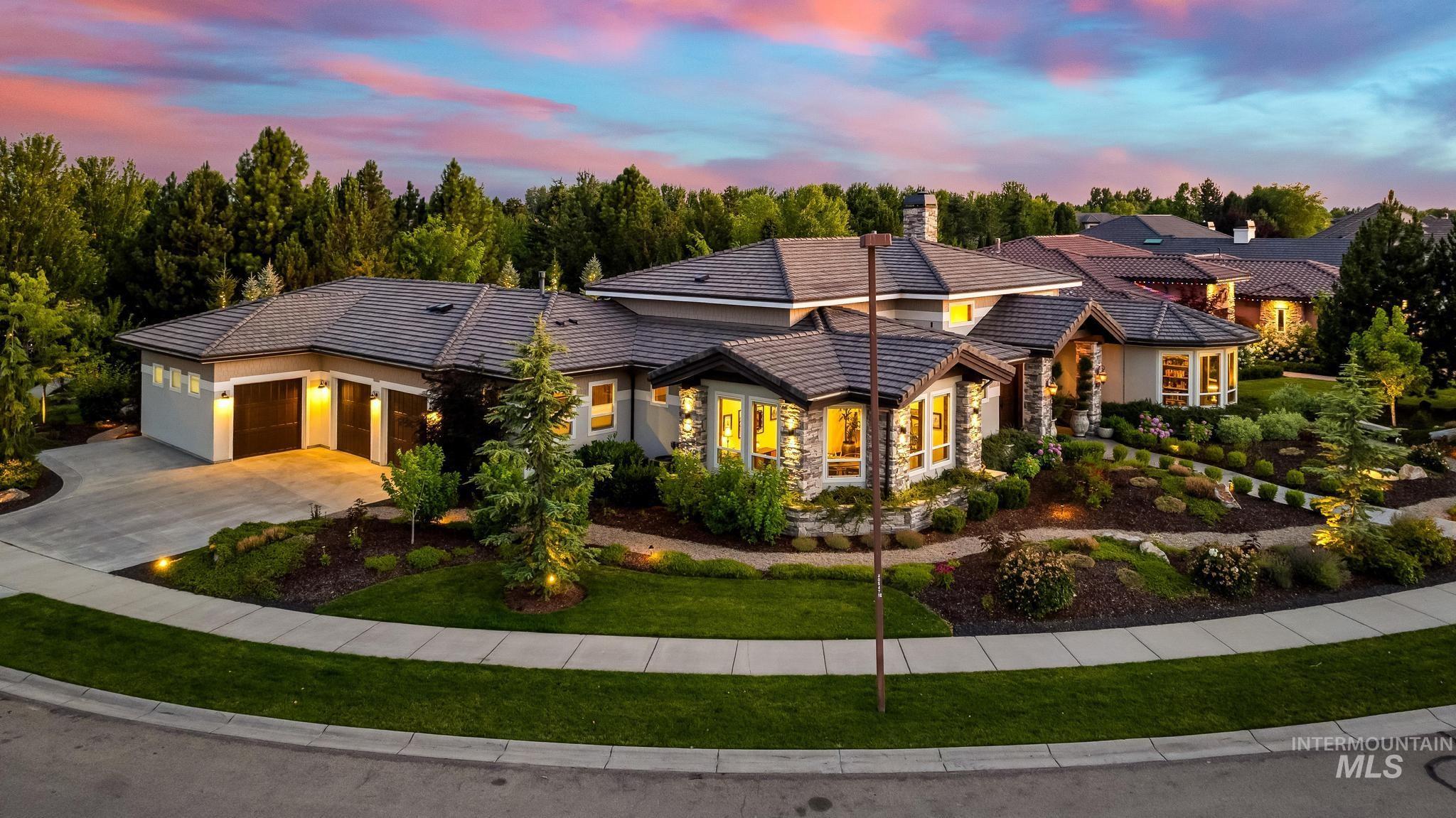 View of front of house featuring driveway, an attached garage, a chimney, stucco siding, and a front yard
