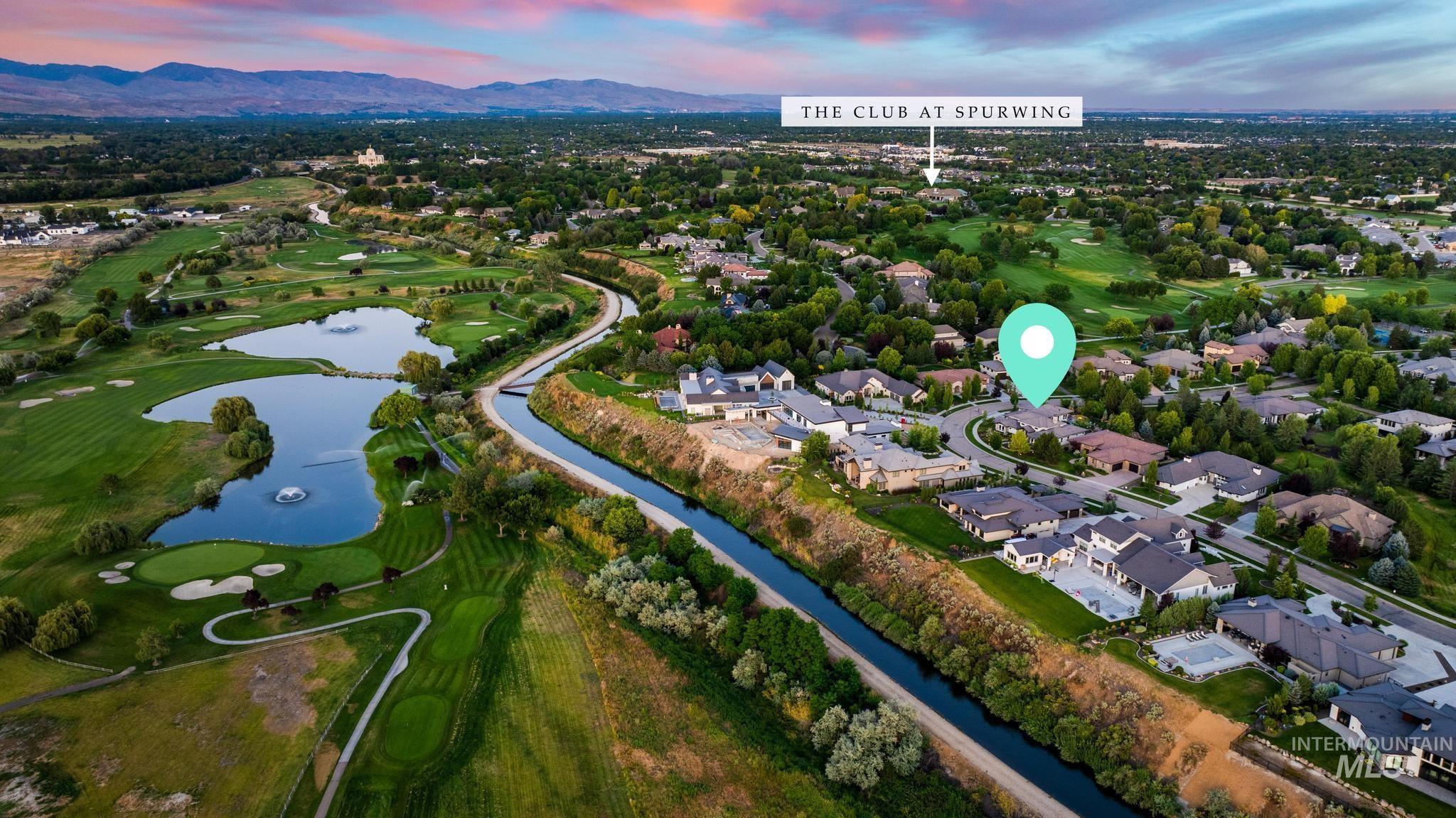 Aerial view of property's location with a water and mountain view, nearby suburban area, and a golf club