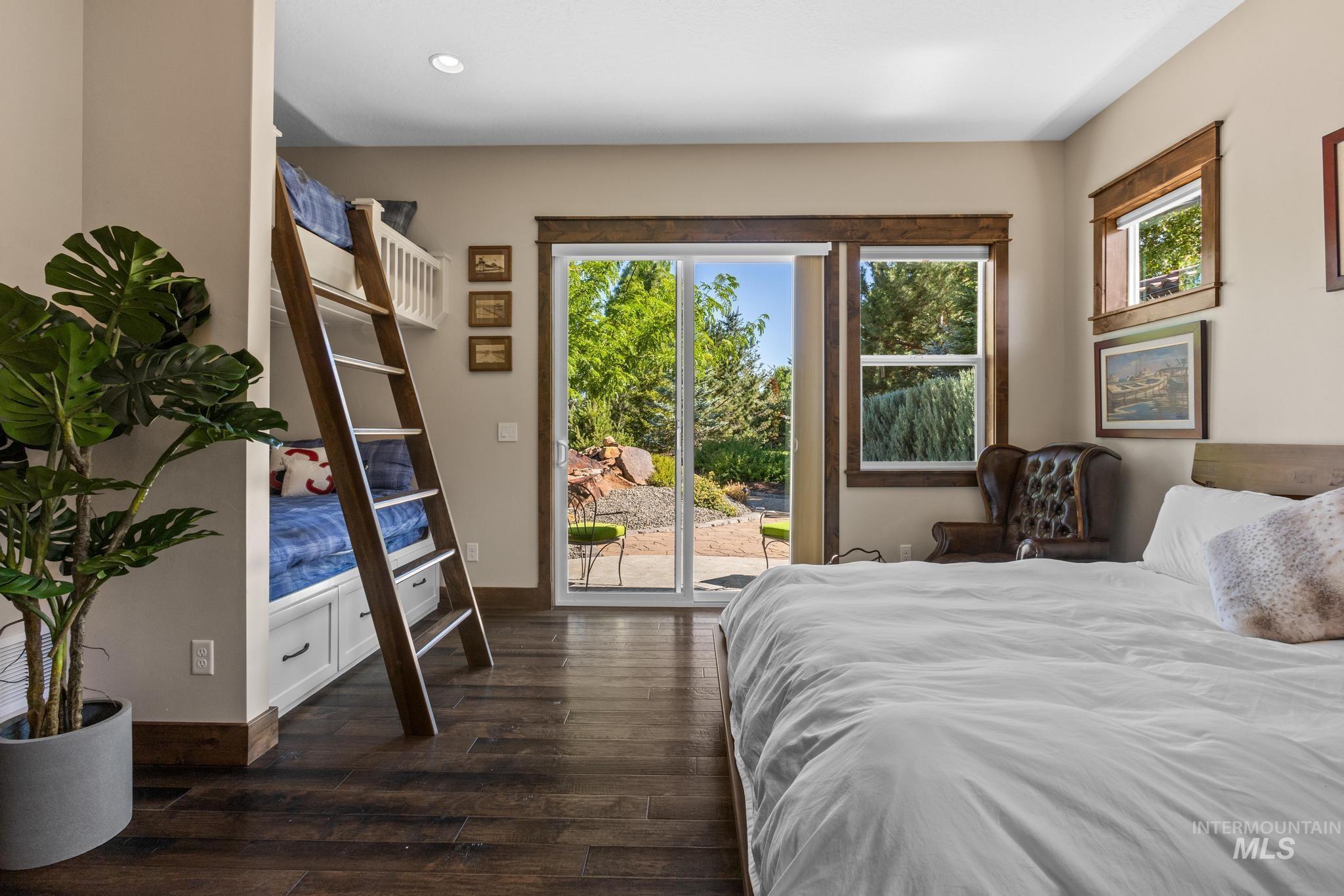 Bedroom with access to exterior, dark wood-style flooring, and recessed lighting