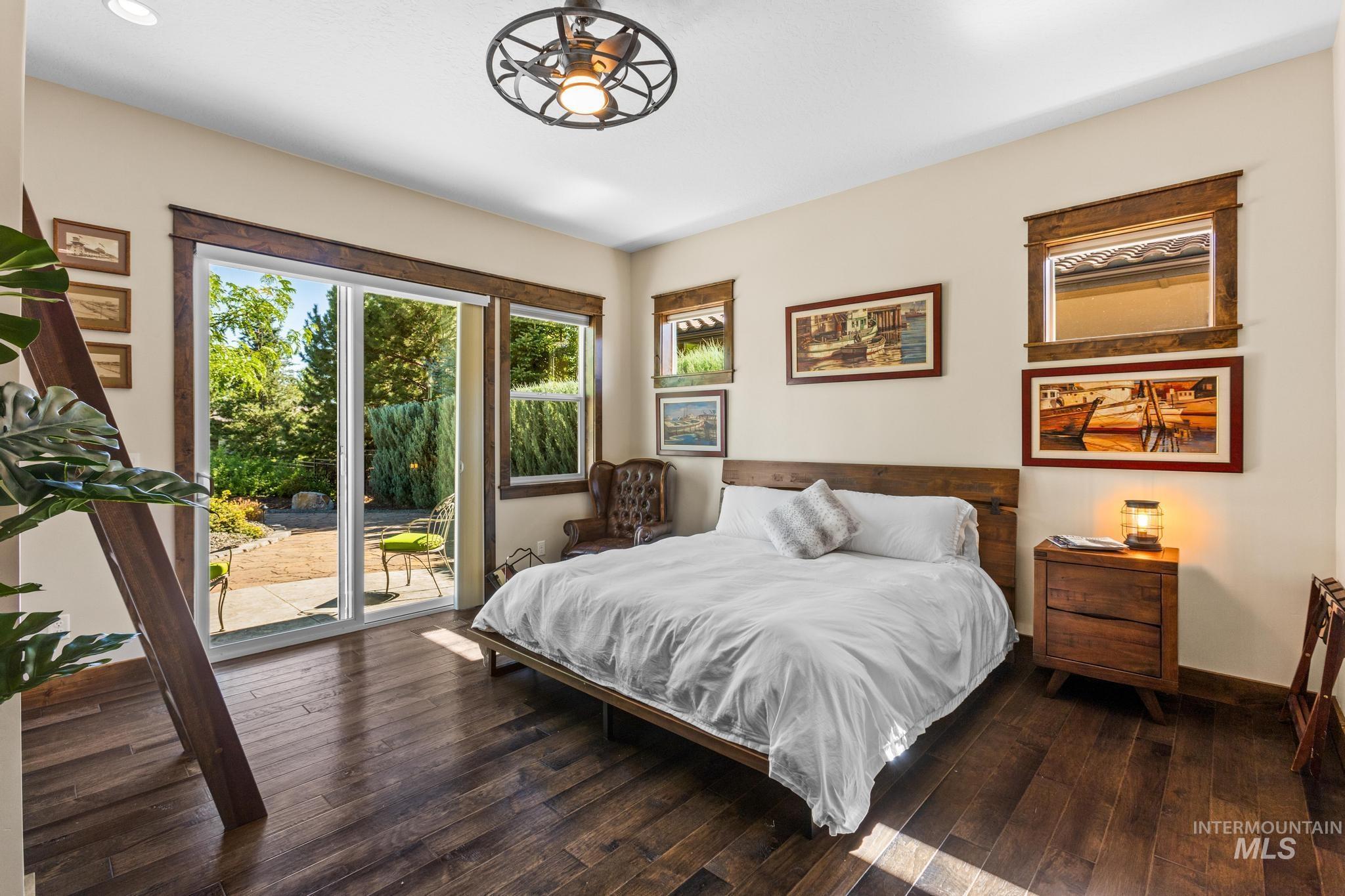 Bedroom with access to outside and dark wood-style flooring